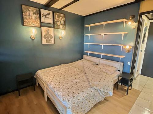 - une chambre avec un lit blanc et un mur bleu dans l'établissement Appartement cosy - Le Chat Gris, à Métabief