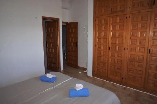 ペゴにあるDanielのベッドルーム1室(青いベッド2台、木製のドア付)