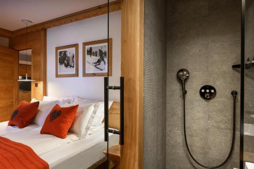 a bedroom with a shower and a bed with orange pillows at Vila Pavlina in Kranjska Gora