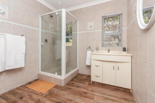 a bathroom with a shower and a sink at Coney Glen Cottage in Knysna