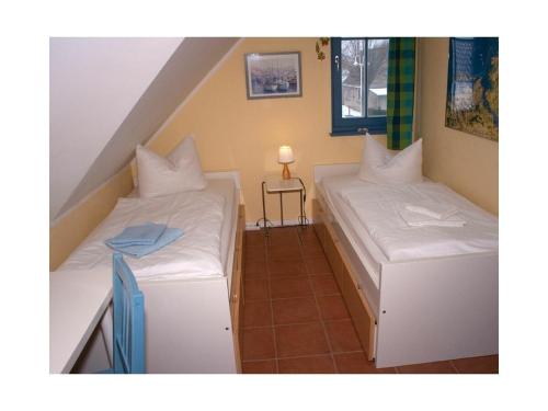 two beds in a small room with a table at Carpe Diem in Zingst