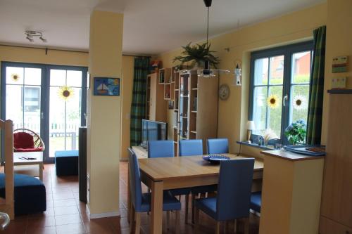 a dining room with a table and blue chairs at Carpe Diem in Zingst