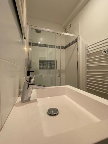 a white bathroom with a sink and a shower at San Valentino House in Bussolengo