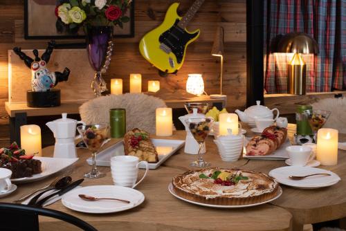 a wooden table with food and candles on it at Snow Lodge Hotel Courchevel 1850 in Courchevel