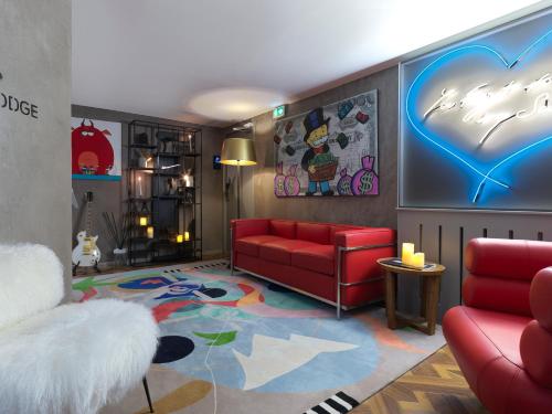 a living room with a red couch and a table at Snow Lodge Hotel Courchevel 1850 in Courchevel
