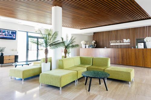 a lobby with a couch and two chairs and a table at Vitors Village in Ferragudo