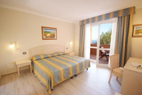 a hotel room with a bed and a balcony at Camping Village Scaglieri in Portoferraio