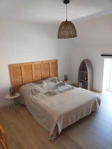 une chambre avec un lit, une table et une lampe dans l'établissement Maison mer Manche Cotentin, à Créances