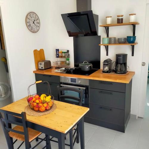 une cuisine avec une table avec un bol de fruits dessus dans l'établissement Maison mer Manche Cotentin, à Créances