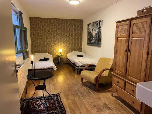 een kleine kamer met 2 bedden en een stoel bij Family house next to train and close to Amsterdam and Schiphol in Almere