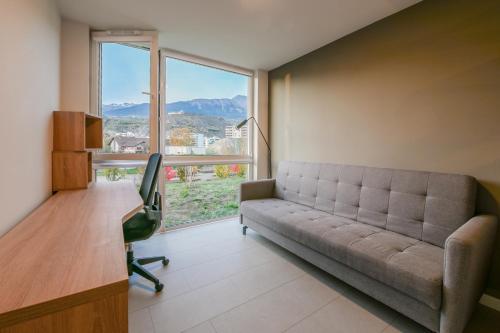 a living room with a couch and a desk and a window at Smallville in Sion