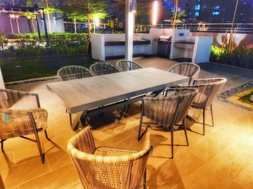 a wooden table and chairs on a patio at Wallaway2stay Gravit8 Andaman Klang 2 Queen Room in Klang