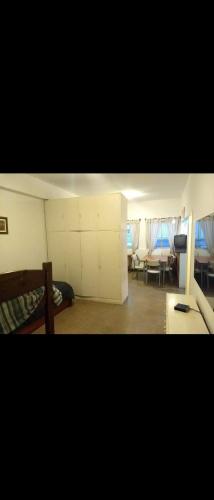 Habitación con cama y sala de estar con mesa. en Depto Alejandro en Mar del Plata