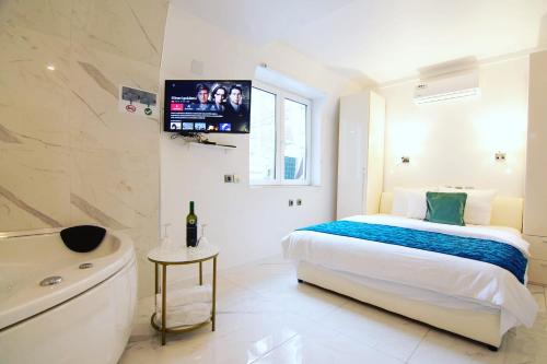 a bedroom with a bed and a tub and a television at Seven Luxury Suites in Belgrade