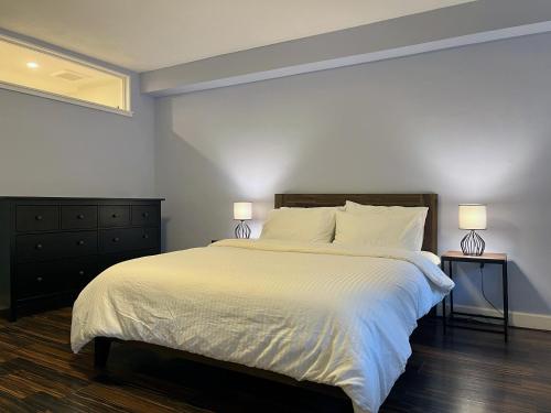 Close to all! 2-room suite in a 1-family townhouse في بروكلين: غرفة نوم بسرير ابيض كبير ومصباحين