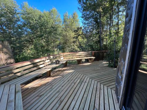 a wooden bench sitting on top of a wooden deck at CABAÑAS BOSQUE NEVADO in Malalcahuello