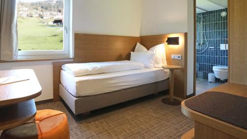 Cette chambre comprend un lit et une salle de bains. dans l'établissement TILL Naturhotel - Self-Check-In, à Satteins