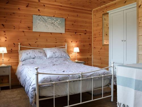 um quarto com uma cama numa parede de madeira em Wiki Wheels em Saint Columb Major