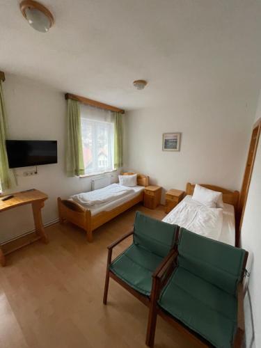 a room with two beds and a chair and a tv at Waldrestaurant VIDA in Kapfenberg