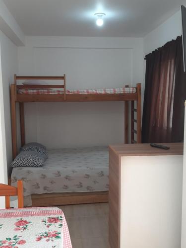 a bedroom with two bunk beds in a room at Quarto em Matinhos PR in Matinhos