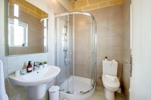 a bathroom with a shower and a sink and a toilet at Dar It-Torri Holiday Home in Kerċem