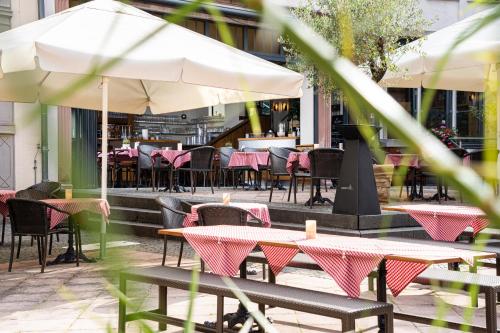 a patio with tables and chairs and an umbrella at Angel's - das hotel am fruchtmarkt in Sankt Wendel
