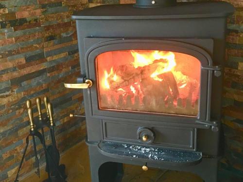 a wood stove with a fire in it at Lakeside Fishing Lodges in Boston