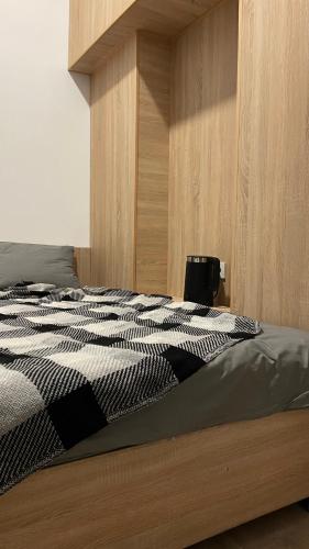 a bedroom with a bed with a black and white comforter at Кімнати в центрі з усіма зручностями та окремим входом in Ivano-Frankivsʼk