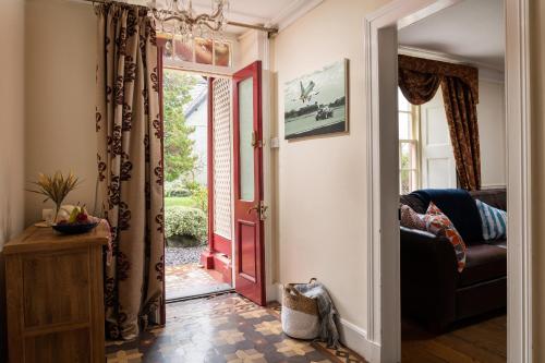a living room with a red door and a couch at Finest Retreats - Bryn Seion in Llanrwst