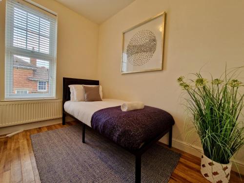 1 dormitorio con cama y ventana en Spacious Luxury Serviced Apartment next to City Centre with Free Parking - Contractors & Relocators, en Coventry