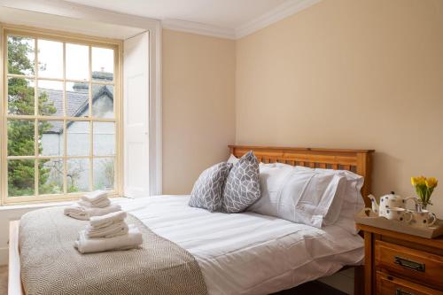 a bedroom with a bed with white sheets and a window at Finest Retreats - Bryn Seion in Llanrwst