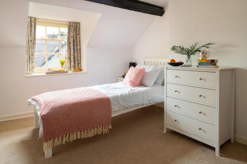 a bedroom with a white bed and a dresser at Finest Retreats - Bryn Seion in Llanrwst