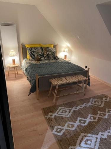 um quarto com uma cama, um banco e um tapete em Emeraude em Changé