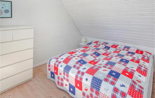 a bedroom with a bed with a red white and blue quilt at Pet Friendly Home In Samsø With Wifi in Onsbjerg