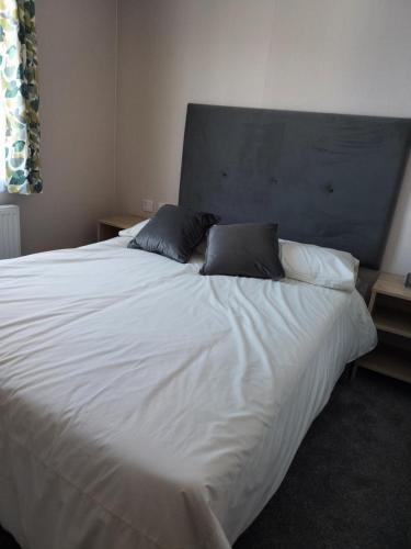 1 cama blanca grande con 2 almohadas en Hoburne Bashley Self-Catering Holiday Home, en New Milton