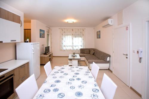 a kitchen and a dining room with a table and chairs at Apartments Maslina III in Njivice