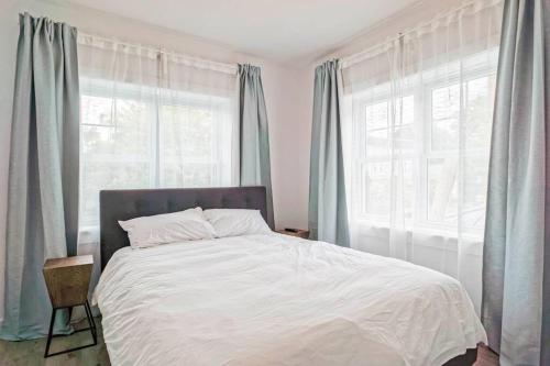 een slaapkamer met een groot bed en blauwe gordijnen bij condo 3 chambres vue sur la montagne 837-202 in Bromont
