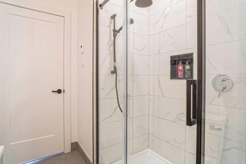 a bathroom with a shower with a glass door at condo 3 chambres vue sur la montagne 837-202 in Bromont