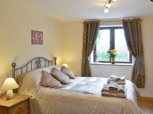 a bedroom with a bed with a window at Annexe Church Farm Barn in Stalham