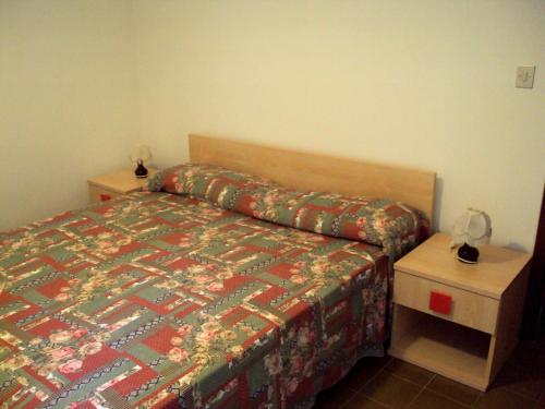 ein Schlafzimmer mit einem Bett und zwei Nachttischen in der Unterkunft Residence Libertà in Grado