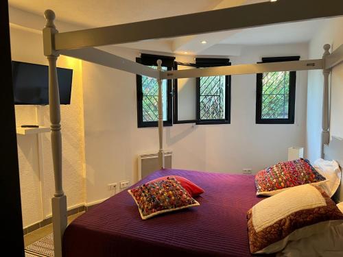 - une chambre avec un lit à baldaquin et des oreillers dans l'établissement Grande Villa 350 M2, piscine chauffée vue mer et collines, CAVALAIRE sur mer, 10 personnes, à Cavalaire-sur-Mer