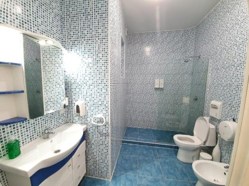 W łazience znajduje się umywalka, toaleta i lustro. w obiekcie Boulevard Ultra Central Apartments in the heart of Chisinau w Kiszyniowie