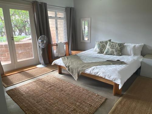 a bedroom with a bed and a large window at Chateau du Windhoek in Windhoek