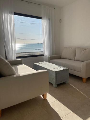 sala de estar con sofá y vistas al océano en DUPLEX frente al mar - Puerto Madryn Vacation Rentals en Puerto Madryn