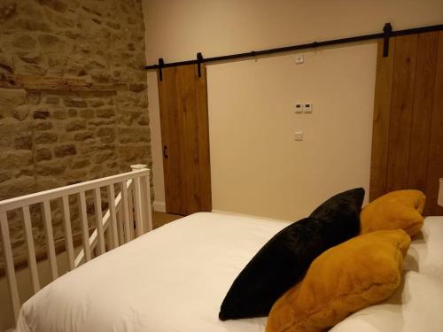 a bed with two large pillows on top of it at Henry's Cottage in Skipton