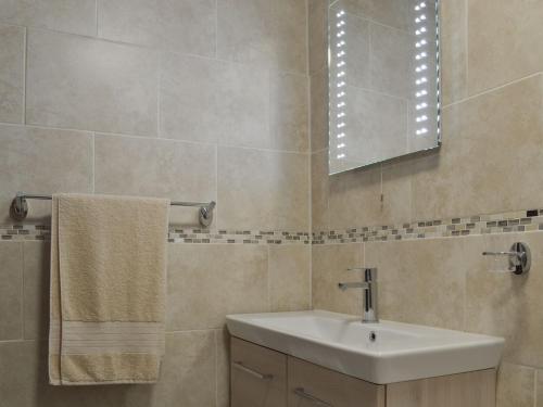 a bathroom with a sink and a mirror at Rose Cottage in Taxal