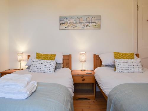 two twin beds in a room with two lamps at Arc House in Cellardyke