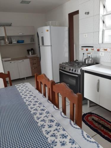 a kitchen with a table and chairs and a refrigerator at Sobrado Em Matinhos Pr in Matinhos