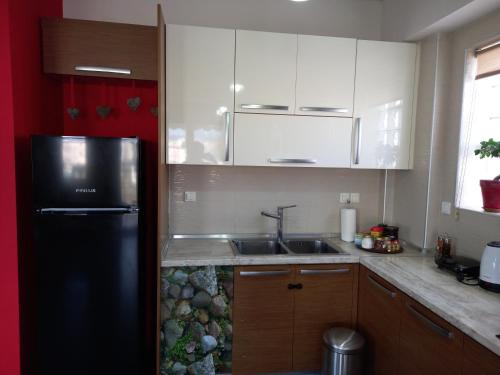 a kitchen with a black refrigerator and a sink at MODERN SWEET HOME WITH AMAZING VIEW!! in Serres
