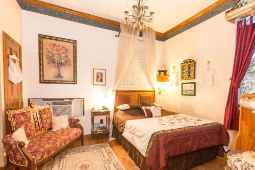 a bedroom with two beds and a chair at The Victorian Cottage at Creekside Camp & Cabins in Marble Falls